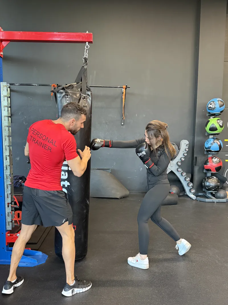 Élève à l’entraînement sur le sac de frappe avec Samy, coach de boxe