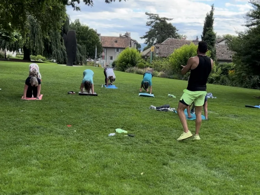 Séance collective en plein air animée par Samy dans un parc à Genève