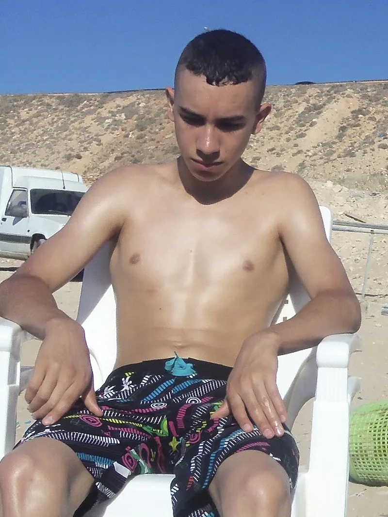 Samy avant sa transformation : adolescent mince, assis sur une chaise de plage